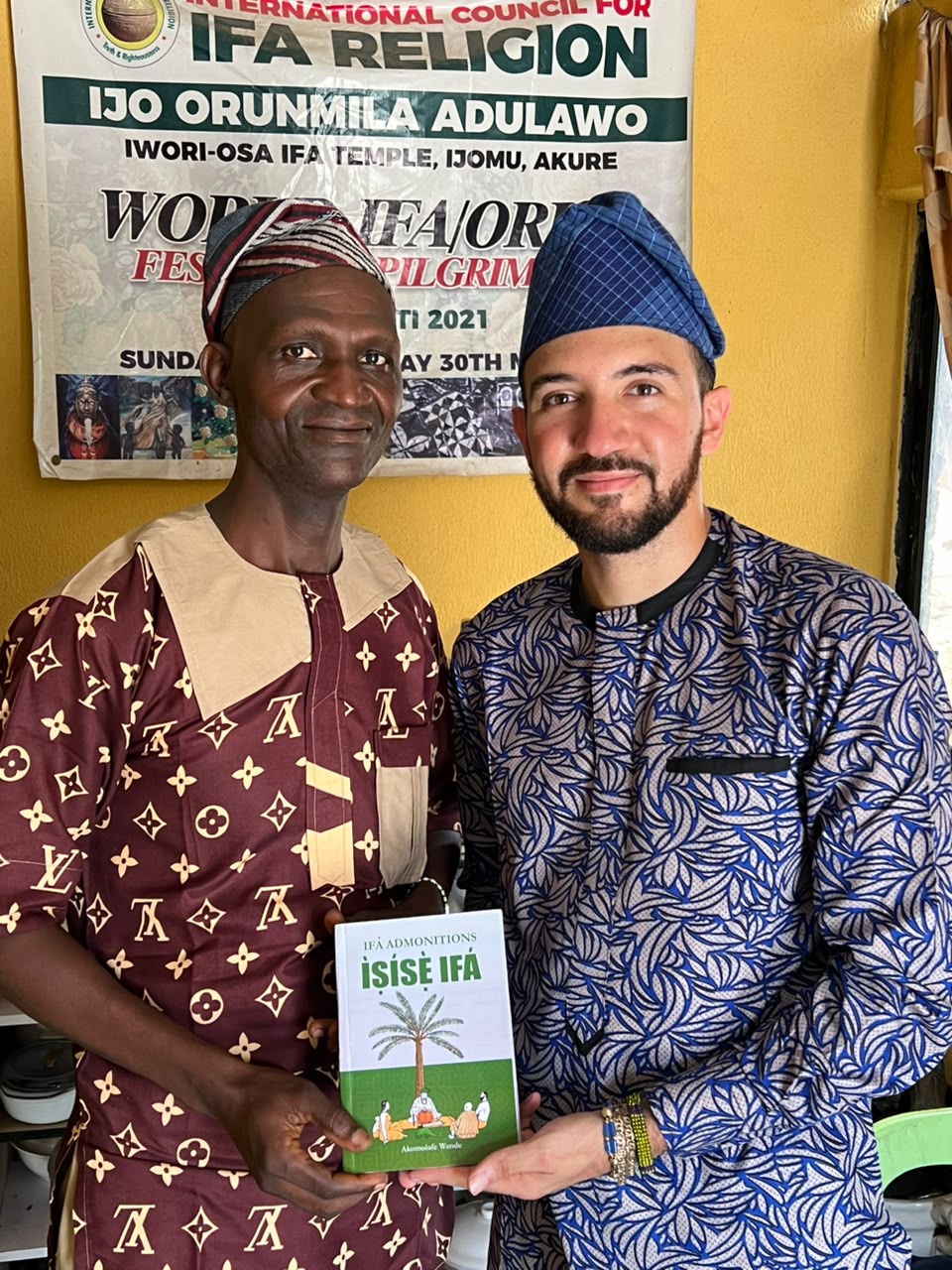 Sahori con un mayor sosteniendo el libro Ìṣẹ̀ṣe Ifá